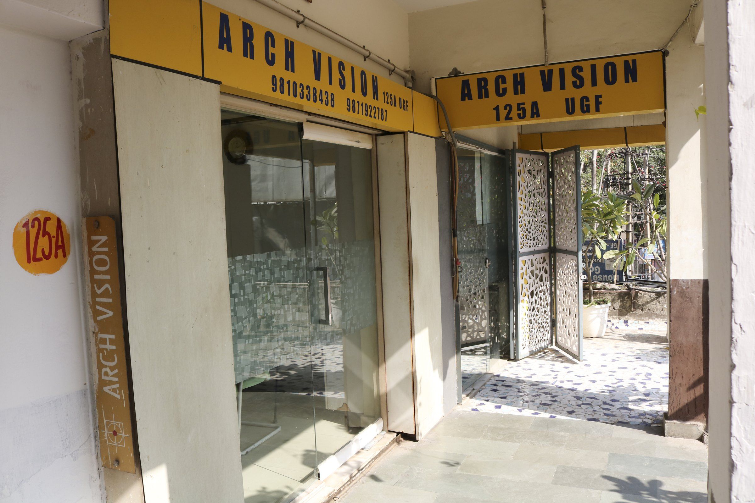 The studio entrance, with the yellow Arch Vision signboard above the glass door of 125-A