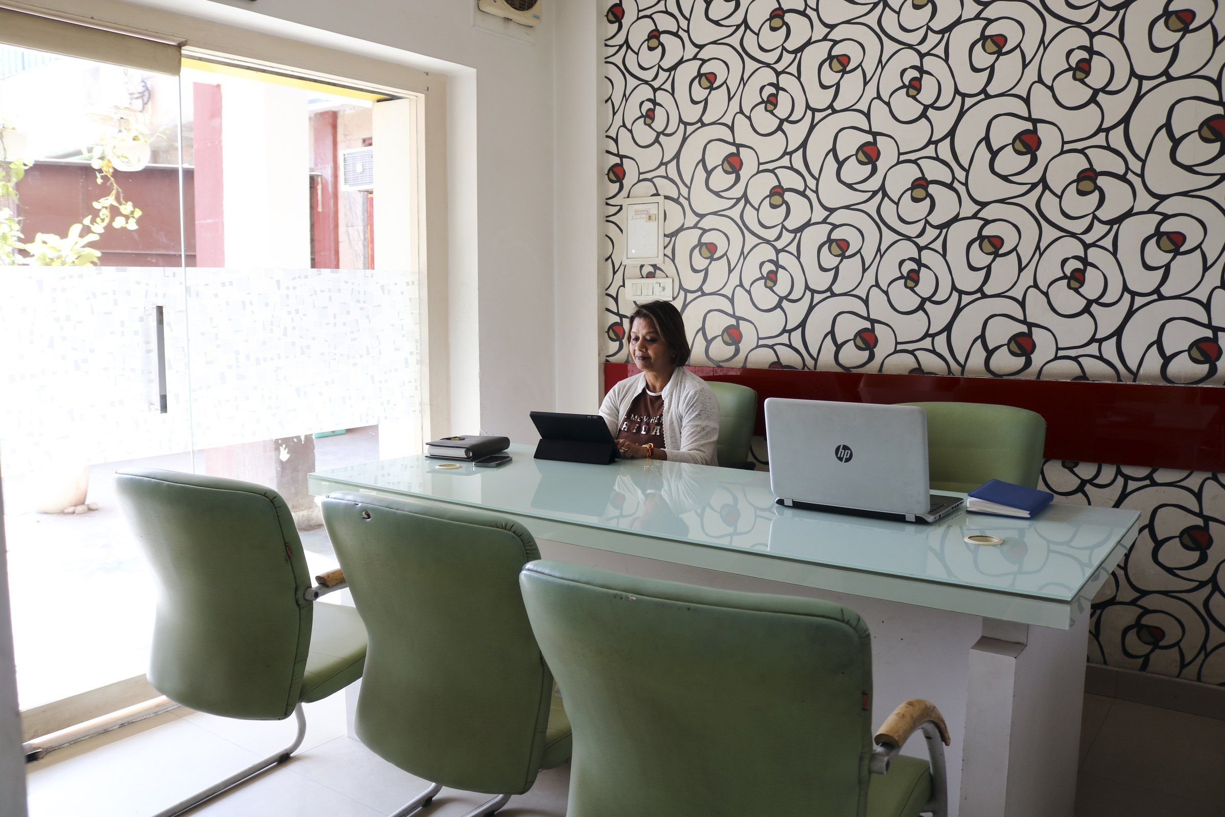 Meeting room in the studio with a glass table and patterned wallpaper