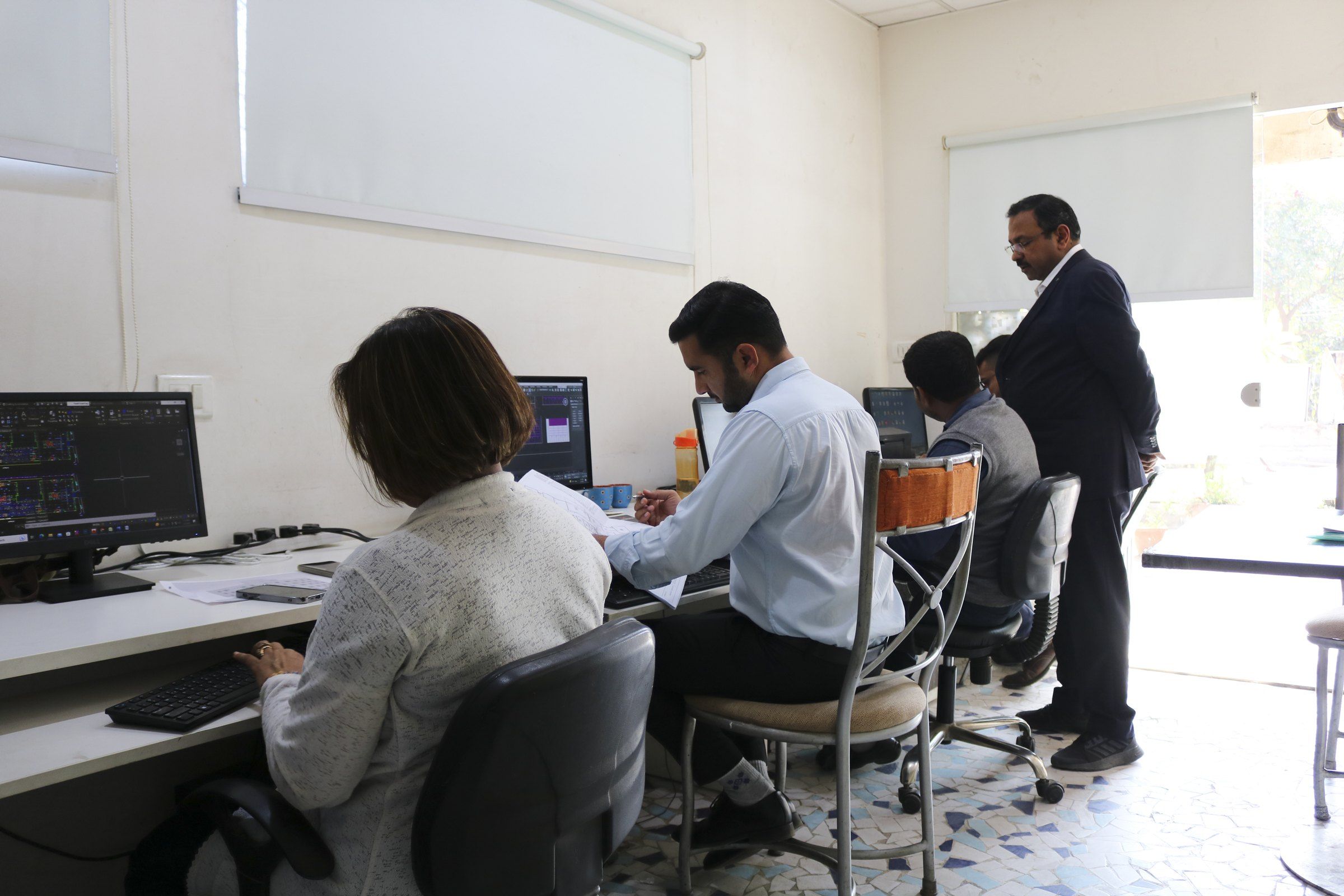 The Arch Vision team at their drawing desks, with the architect looking over a design